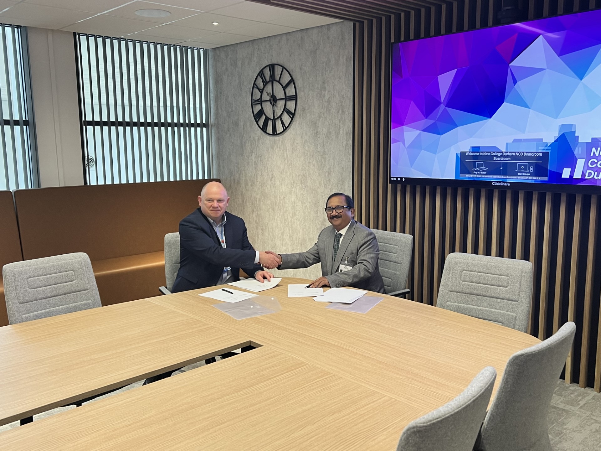Andy Broadbent, Principal and CEO of 91, and Dr Padmesh Gupta, Managing Director of Oxford Business College, seal the new partnership